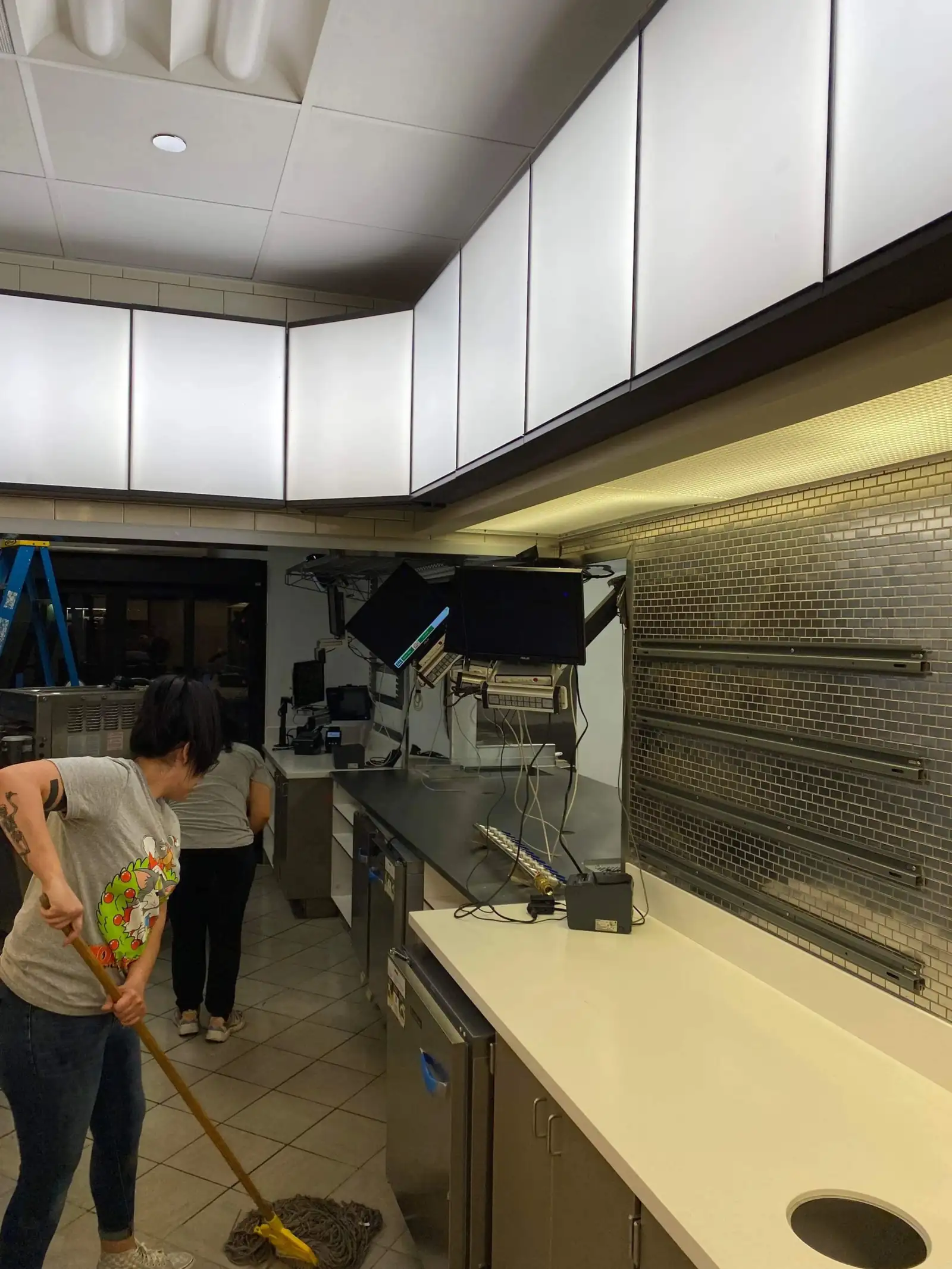 Technician detailing kitchen surfaces during a scheduled restaurant cleaning